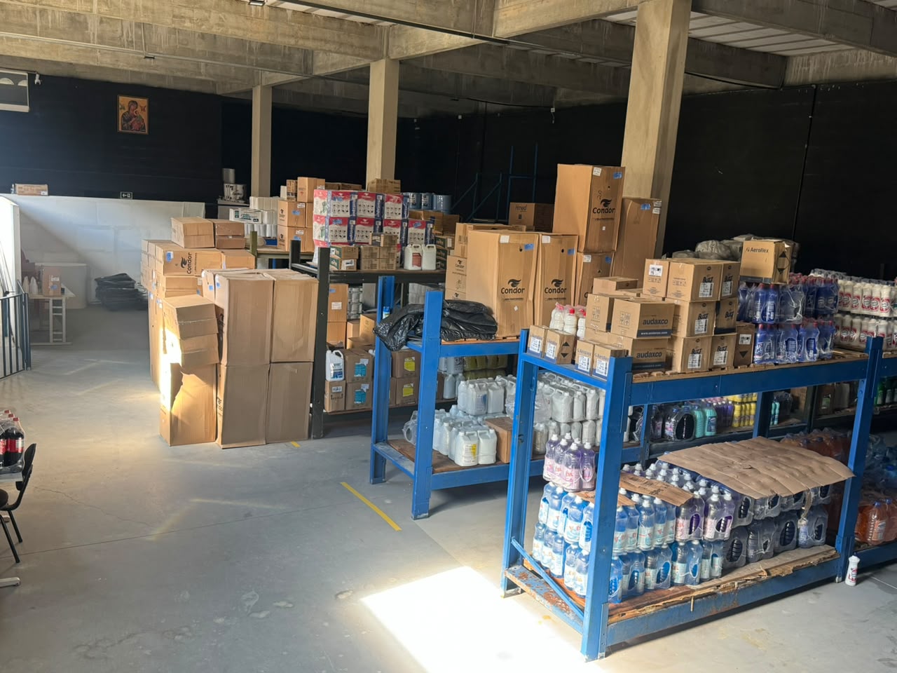 Estoque da JDM Distribuidora com produtos organizados em paletes e prateleiras